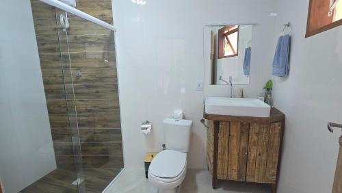 Un baño con inodoro, lavabo y ducha. en Suite Pássaros, en Ilhabela