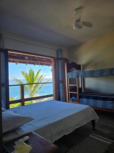 Un dormitorio con una cama y vista al mar. en Suite Pássaros, en Ilhabela