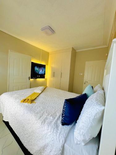 a bedroom with a bed with blue and white pillows at Nouvelle BNB in Gaborone