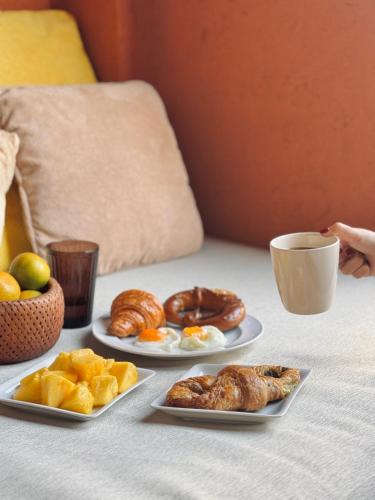 a table with three plates of pastries and a cup of coffee at Las Tortugas beach front condo in Khao Tao