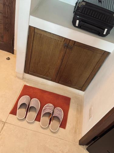 two pairs of shoes sitting on a rug in a kitchen at Las Tortugas beach front condo in Khao Tao