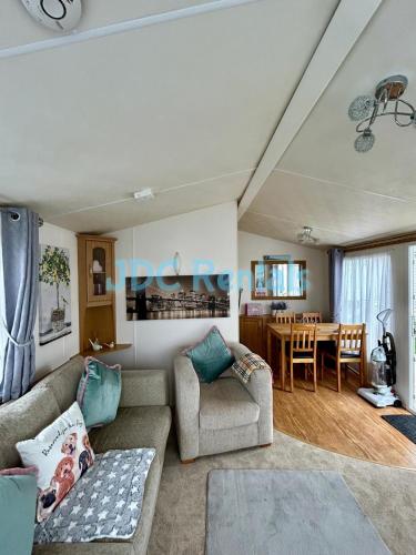 a living room with a couch and a table at Golden Sands & Winkups in Kinmel Bay