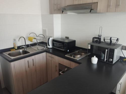 a kitchen with a sink and a microwave at Cumbres de reñaca in Viña del Mar