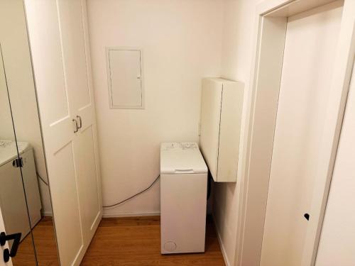 a small white refrigerator in a room with a door at Charmantes Apartment - für 2-4 Personen - modern, ruhig, Parkplatz in Passau