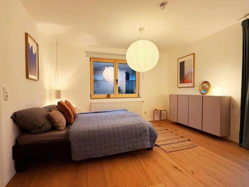 a bedroom with a bed and a couch and a window at Charmantes Apartment - für 2-4 Personen - modern, ruhig, Parkplatz in Passau
