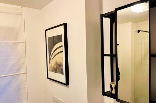 a mirror hanging on a wall next to a bathroom at Charmantes Apartment - für 2-4 Personen - modern, ruhig, Parkplatz in Passau