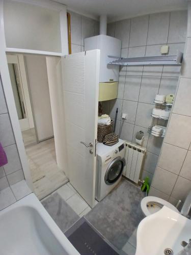 a small bathroom with a washing machine and a sink at 4th Floor Apartment in Sarajevo