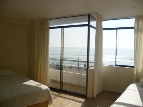 a bedroom with a view of the ocean at Hotel Huankarute in Huanchaco