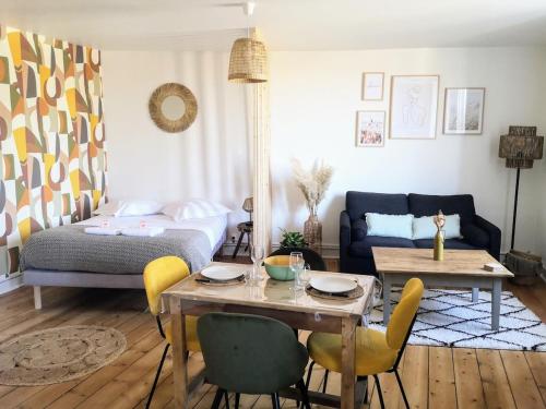 ein Wohnzimmer mit einem Bett und einem Tisch und Stühlen in der Unterkunft Appartement studio Cosy Centre-Ville in Auray