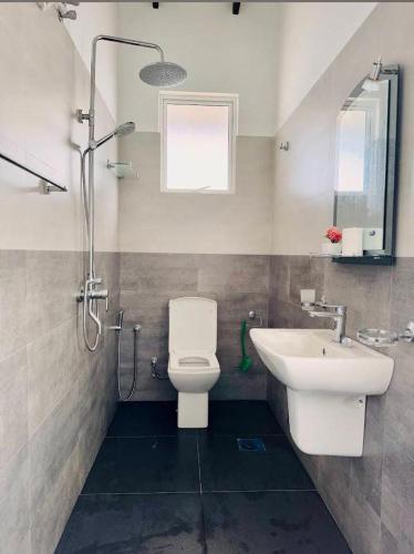 a bathroom with a toilet and a sink at Sunset Beach Villa in Galle