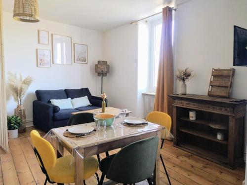 un salon avec une table, des chaises et un canapé dans l'établissement Appartement studio Cosy Centre-Ville, à Auray
