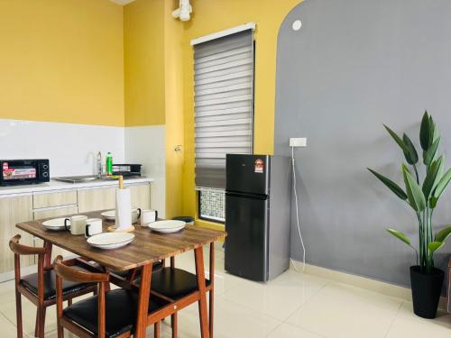 a kitchen with a wooden table and a refrigerator at Core Soho Suites Kota Warisan Sepang KLIA Airport Free Wifi by BKA LEGACY in Sepang