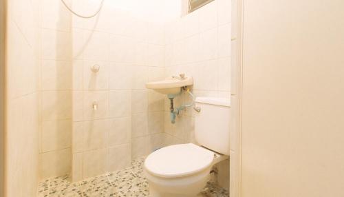 a white bathroom with a toilet and a shower at RedDoorz at La Maria Pension And Tourist Inn in Cebu City