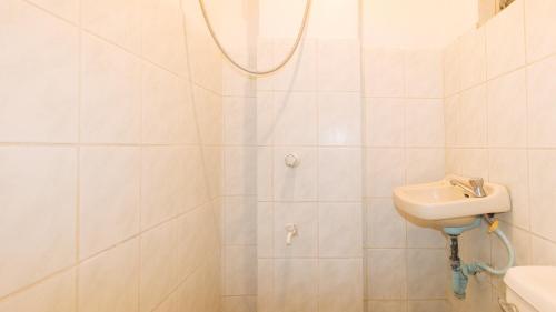 a white bathroom with a sink and a shower at RedDoorz at La Maria Pension And Tourist Inn in Cebu City
