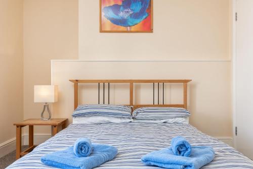 a bed with two blue towels on top of it at Abbey Terrace - Free Parking in Whitby