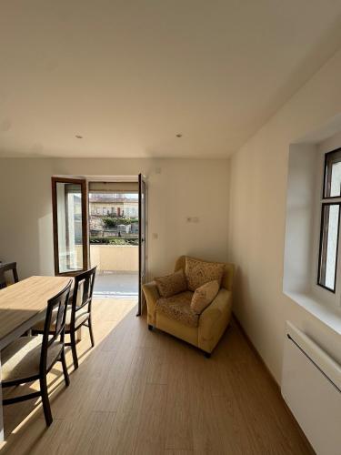 un salon avec une table et un canapé dans l'établissement Appartement T3 rénové cœur de St Priest Parking Privé, à Saint-Priest