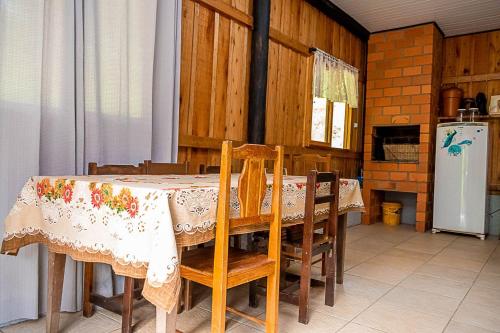 a dining room with a table with chairs and a refrigerator at Sitio do Alemão in Benedito Novo