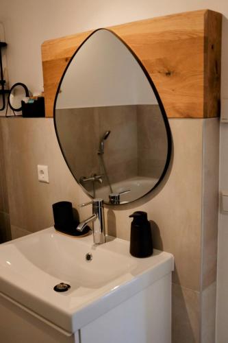 a mirror on top of a bathroom sink at FEWO Silberberg in Dornstetten