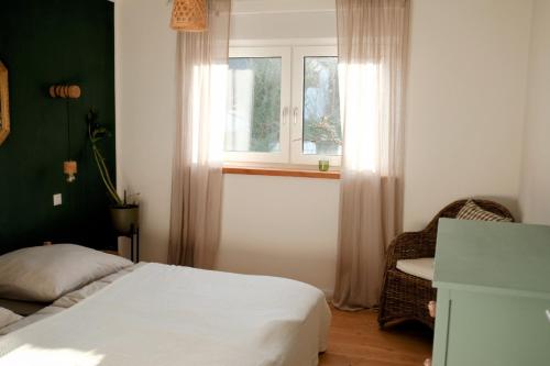 a bedroom with a bed and a window and a chair at FEWO Silberberg in Dornstetten