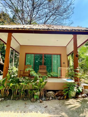 a house with a large window and a tub at Sunny Cove Beach Resort Koh Phayam in Ranong