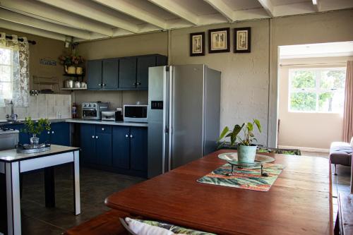 a kitchen with a table and a refrigerator at Tranquility Farmstays in Winterton