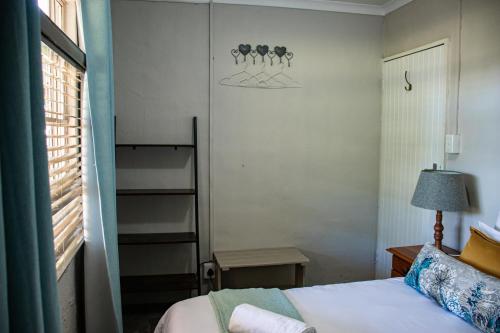 a small bedroom with a bed and a window at Tranquility Farmstays in Winterton