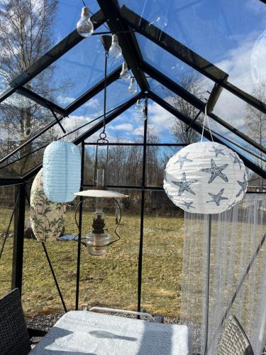 a greenhouse with two chandeliers and a table in it at Boende Sannerud Tived in Tived