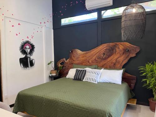 a bedroom with a bed with a wooden headboard at Mecca in Puerto Viejo
