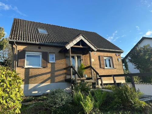 a brown brick house with a black roof at Raelax in Raeren