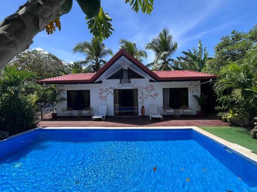 a villa with a swimming pool in front of a house at Mecca in Puerto Viejo