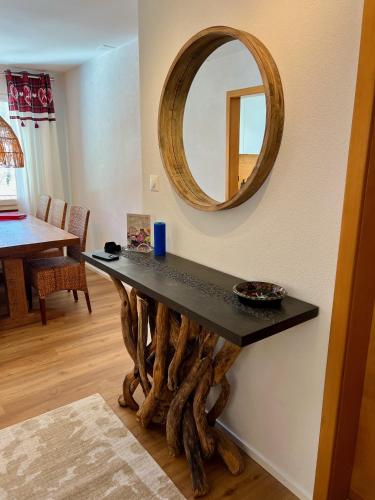 a table with a mirror on a wall at Chalet zur Höhe in Grindelwald
