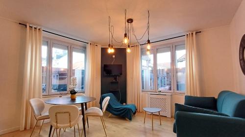 un salon avec un canapé, une table et des chaises dans l'établissement CalaisBlack 2-4 personnes Centre Ville, à Calais