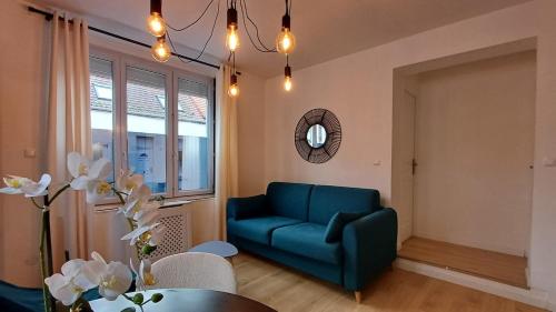 un salon avec un canapé bleu et une table dans l'établissement CalaisBlack 2-4 personnes Centre Ville, à Calais