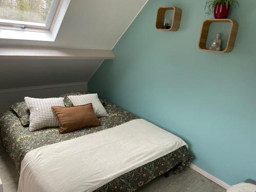 a bed with pillows on it in a room at Charmant appartement tout équipé in Noisy-sur-École