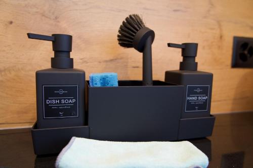 a black holder with two toothbrushes and a brush at Chalet zur Höhe in Grindelwald