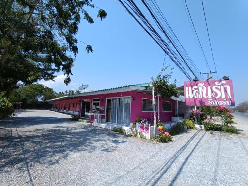 a pink building with a sign for a hospital at Saan Rak Resort in Prachuap Khiri Khan