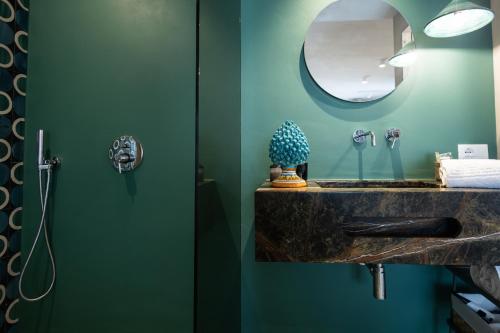 a bathroom with a sink and a mirror at Oikos Rooms in Marsala