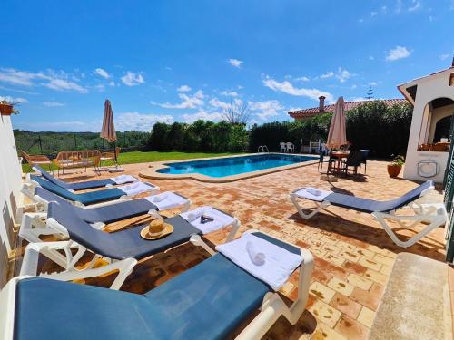 a group of lounge chairs and a swimming pool at Villa Nuralux - Vistas Espectaculares, Piscina Privada y BBQ in Sant Climent