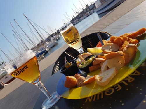 une assiette de nourriture sur une table avec un verre de bière dans l'établissement Appartement Cap d'Agde, au Cap d'Agde