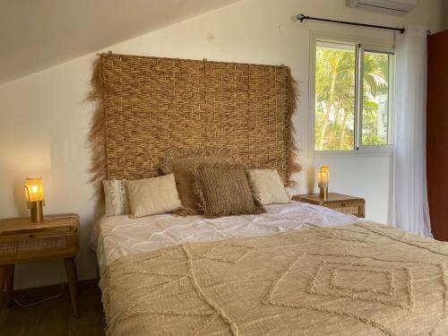 a bedroom with a large bed with two lamps on tables at Villa Rosa Palma 10 personnes piscine chauffée à St Gilles les bains in Saint-Paul