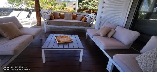 a screened in porch with couches and a coffee table at Villa Rosa Palma 10 personnes piscine chauffée à St Gilles les bains in Saint-Paul