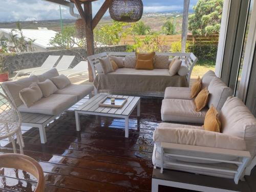 a living room with couches and a table at Villa Rosa Palma 10 personnes piscine chauffée à St Gilles les bains in Saint-Paul