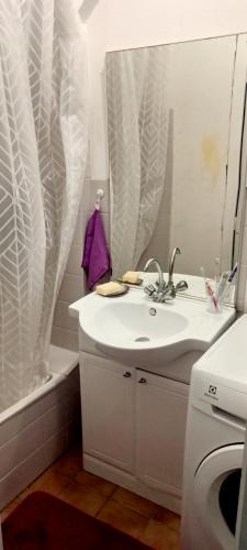 une salle de bain blanche avec un lavabo et un miroir dans l'établissement T2 Petit nid douillet proche de la plage et la ville close, à Concarneau