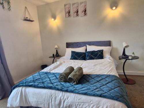 a bedroom with a bed with a blue blanket and pillows at Slough Luxhaven Elegant One-Bed Apartment on High Street in Slough