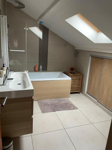 une grande salle de bain avec une baignoire et un lavabo dans l'établissement Grande maison dans les Pyrénées, à Argelès-Gazost
