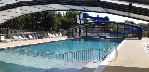 une grande piscine avec un toboggan aquatique dans l'établissement mobile home 6 personnes-3 chambres, à La Boissière-de-Montaigu