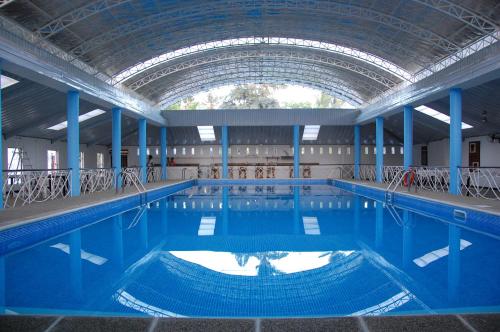 a large swimming pool with a large ceiling at Balay Tuko Garden Inn in Puerto Princesa City