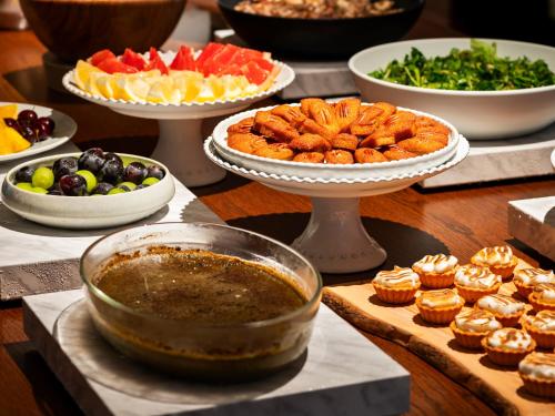 a table with plates of food and bowls of food at Mitsui Garden Hotel Kyoto Sanjo PREMIER in Kyoto