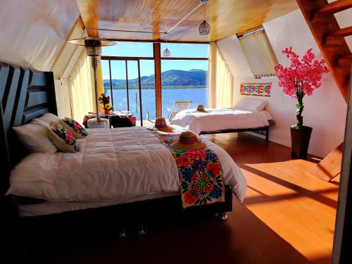 a bedroom with two beds and a view of the water at titicaca lodge jutma in Puno