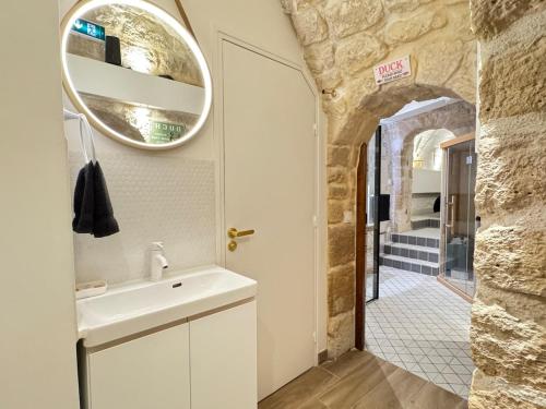 une salle de bain avec un lavabo et un miroir dans l'établissement MONA LiSA - 110 m2 Luxury flat in Le Marais - AC, à Paris